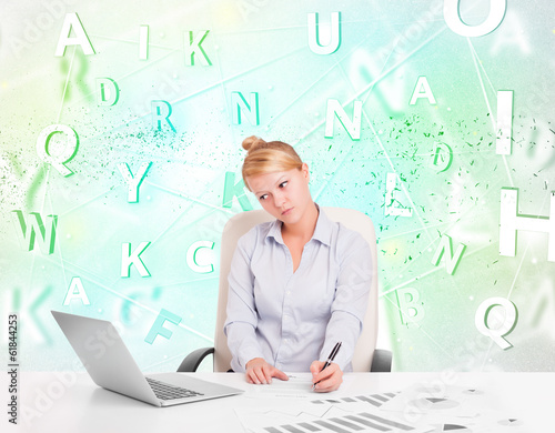 Business woman at desk with green word cloud