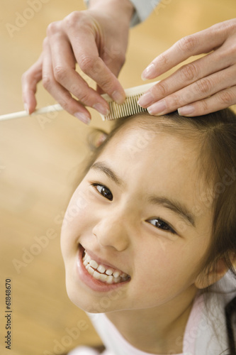 girl having her hair combed