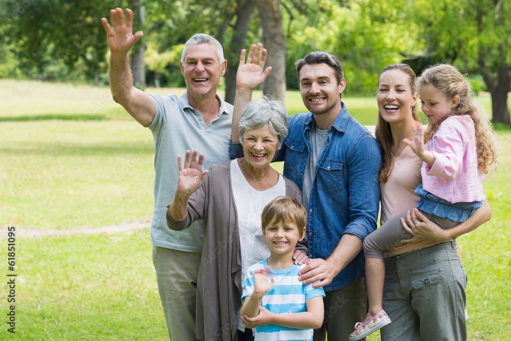 Happy extended family waving hands at park Happy extended family waving hands at park
