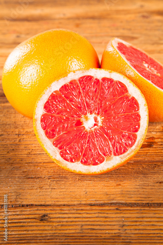 Fresh grapefruit with slices on a wooden table. Wooden backgroun