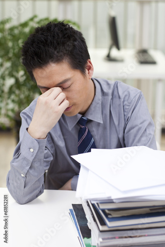 .A man looks stressed as he works at his desk.