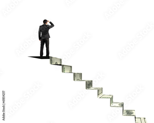 Man gazing on top of money stairs