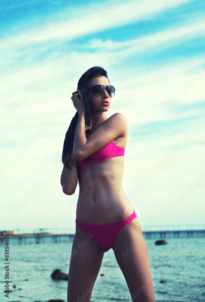 Sexy brunette on vacation wearing sunglasses - obrazy, fototapety, plakaty 