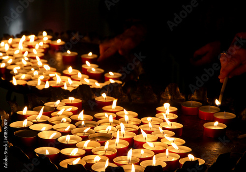 hands of an elderly woman lighting a candle photo