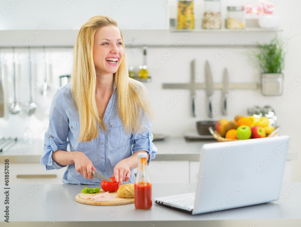Smiling young woman making snacks in kitchen Smiling young woman making snacks in kitchen