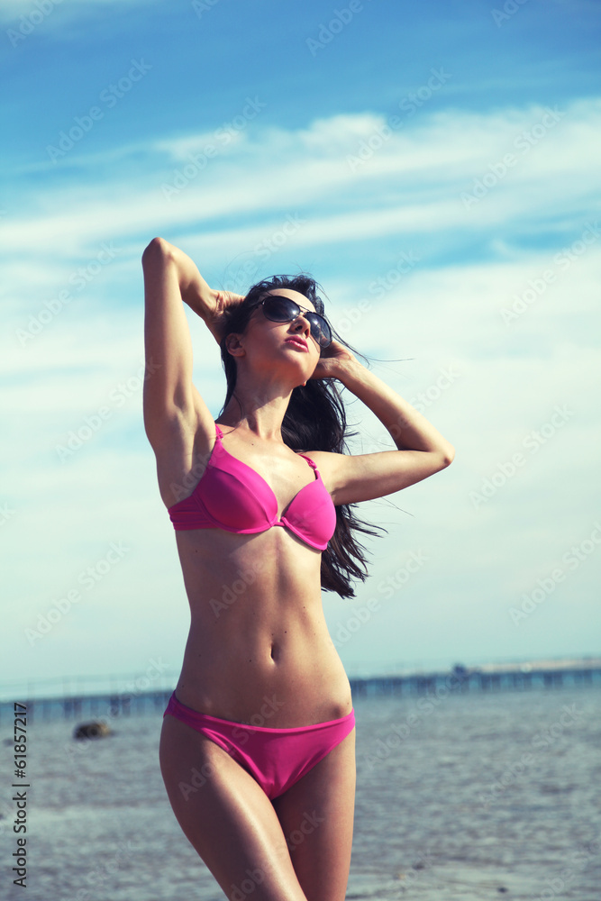 Slim attractive woman tans on the beach - obrazy, fototapety, plakaty 