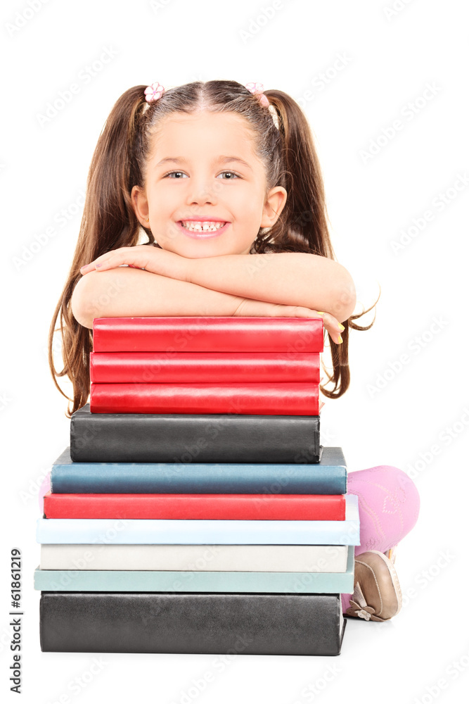 Little girl sitting on the floor behind stack of books Little girl sitting on the floor behind stack of books