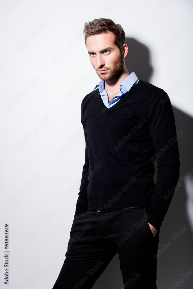 Fototapeta premium Fashion portrait of young man in black pullover.