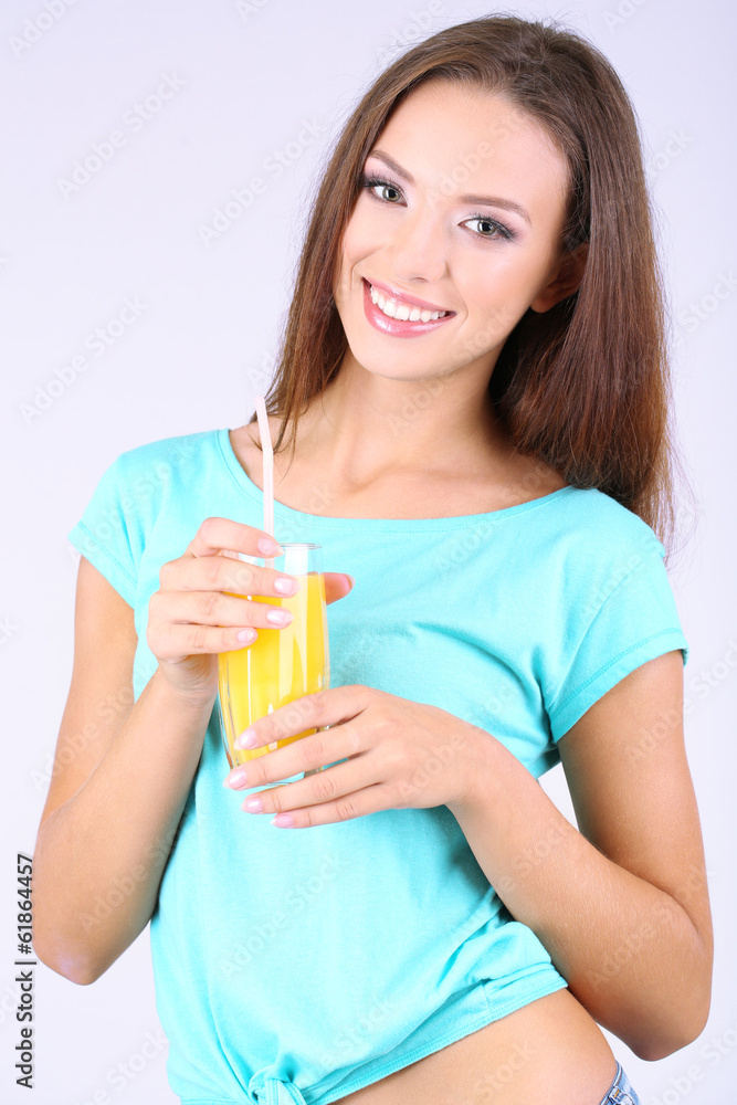 Beautiful girl with fresh juice on grey background Beautiful girl with fresh juice on grey background