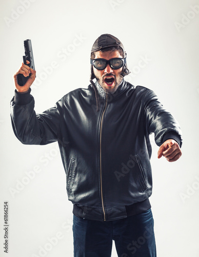 Disguised angry man holding a gun threatening