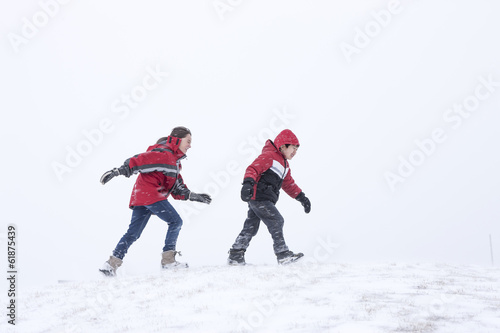 Kids walking while snowing.
