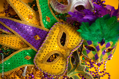 Colorful group of Mardi Gras or venetian masks on yellow © Michael Flippo