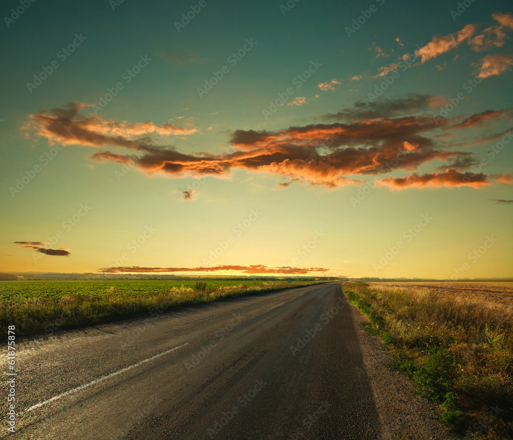 Lonely road leading to the horizon at sunset sky background