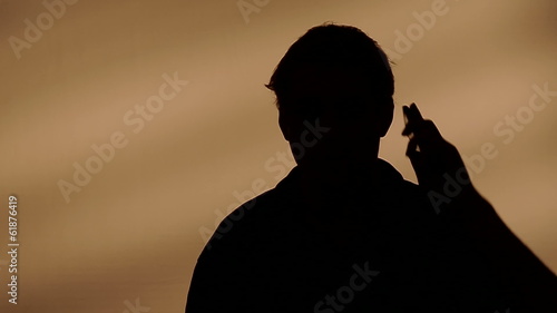 Male silhouette calling on the phone.