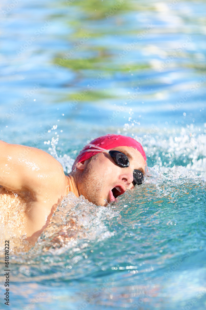 Swimmer man swimming crawl in blue water
