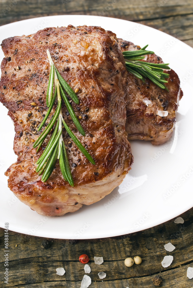 Beef steak on a wooden table. Beef steak on a wooden table.