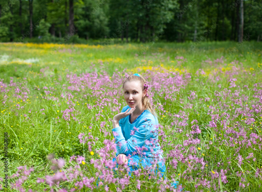 The happy young woman in the field of wild flowers.. The happy young woman in the field of wild flowers..