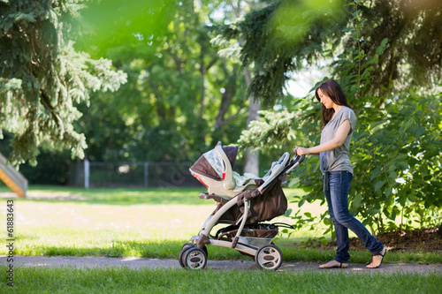 Bild auf Leinwand Mother Pushing Stroller In The Park