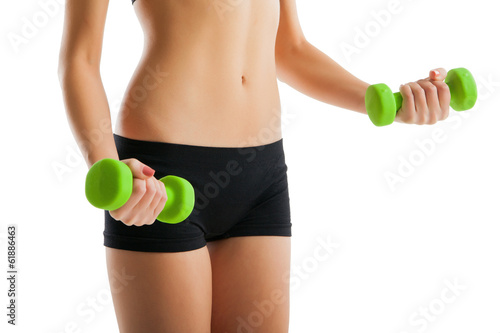 Body of young fit woman lifting dumbbells