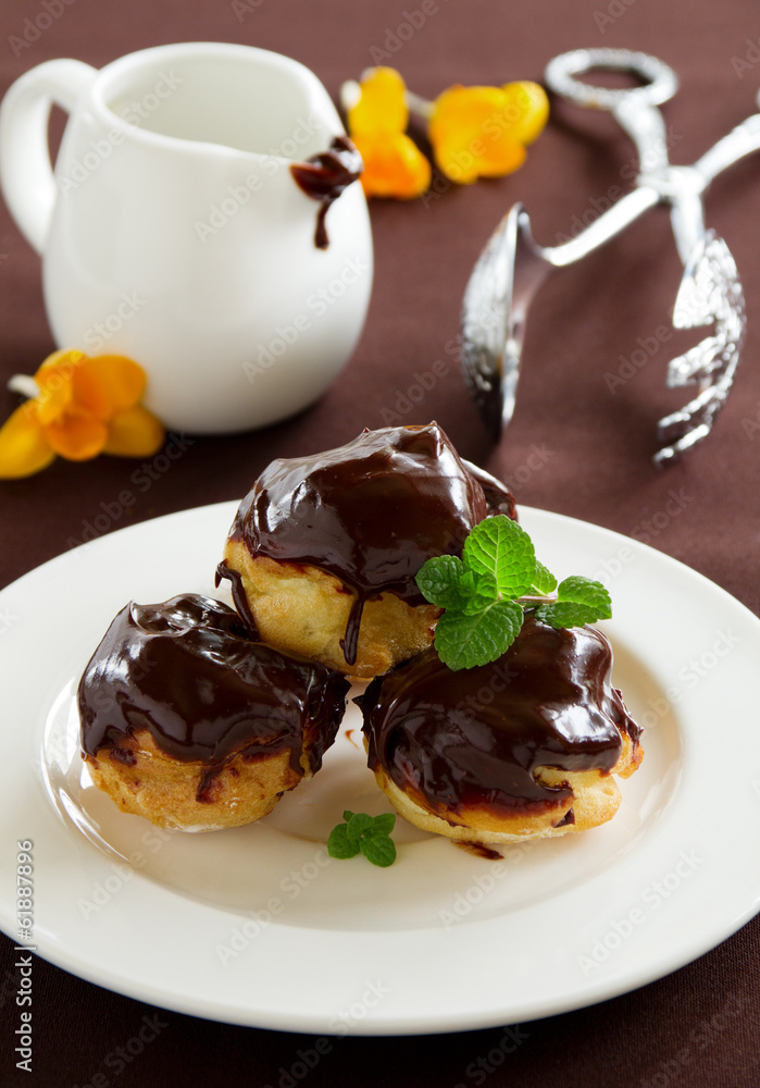 profiteroles with cream and chocolate sauce. profiteroles with cream and chocolate sauce.