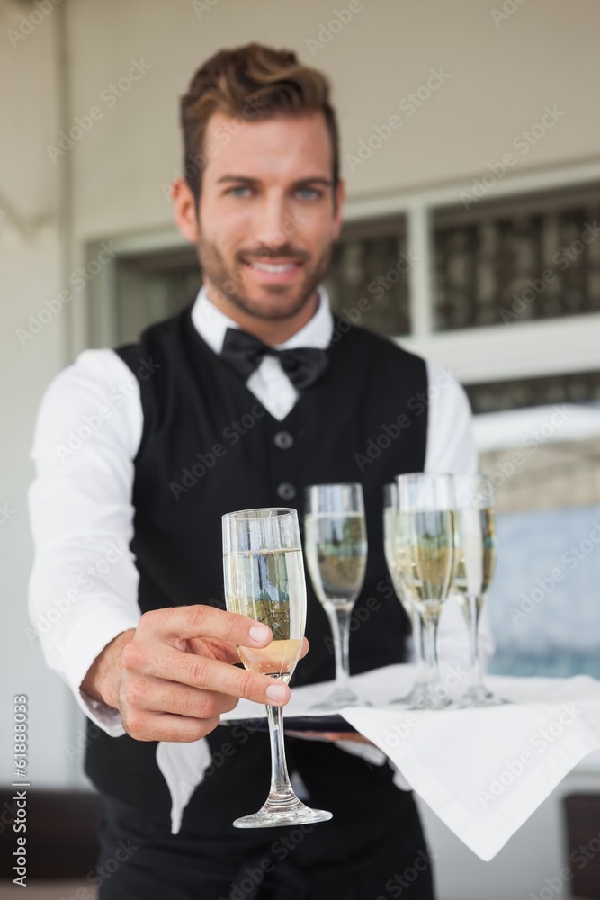 Handsome waiter offering flute of champagne Handsome waiter offering flute of champagne