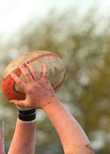 Hands holding a rugby ball photo