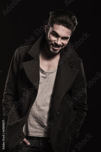 relaxed fashion man with beard smiling, hands in pockets