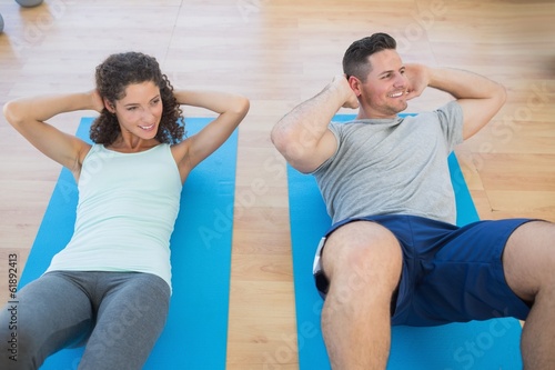 Couple doing sit ups at gym