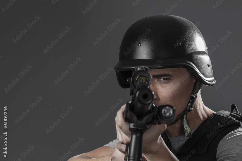 Assault, paintball sport player wearing protective helmet aiming