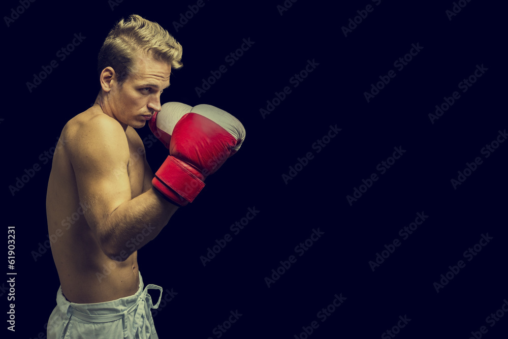 Young male boxer on a dark background