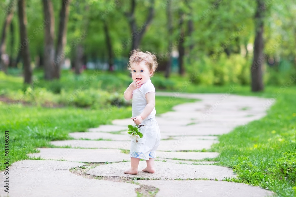 Adorable baby girl walking in a beautiful summer garden Adorable baby girl walking in a beautiful summer garden