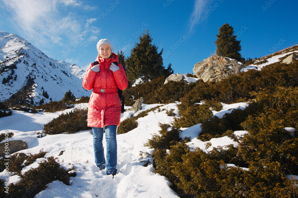 Young woman take a walk on winter mountain slope