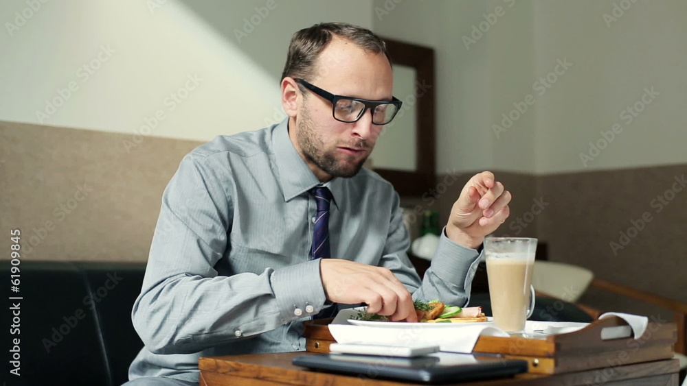 Young businessman eating tasty breakfast in hotel room Young businessman eating tasty breakfast in hotel room
