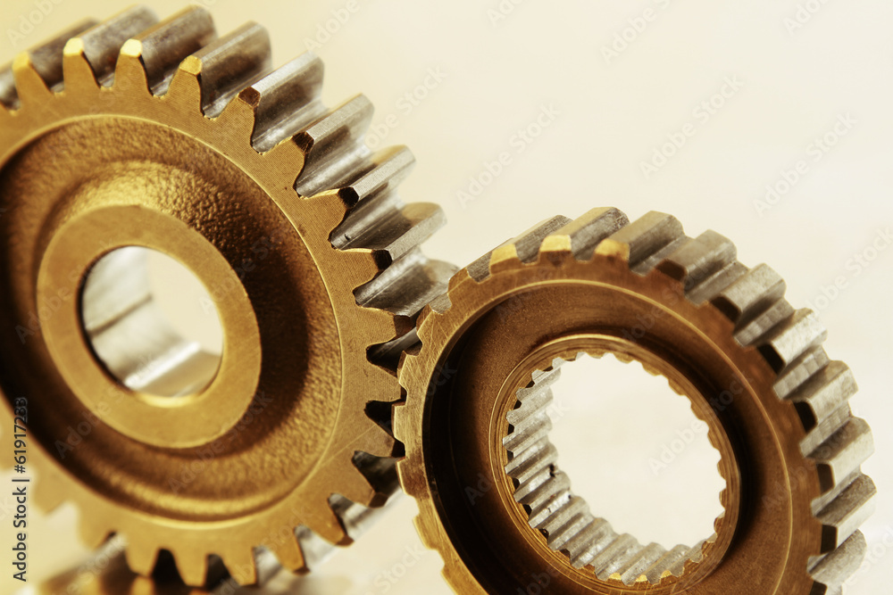 Two steel cog gears bonding together. Teamwork