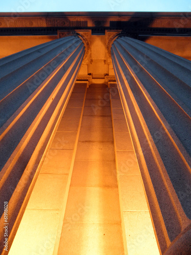 Looking upwards at Columns light up with Orange light at Dusk