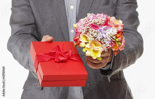 Man holding colorful bouquet of freesia flowers and red box