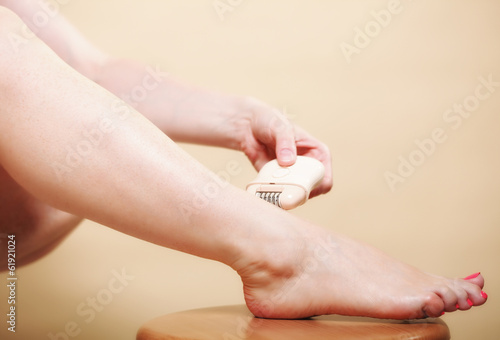 woman shaving leg with shaver depilation body care
