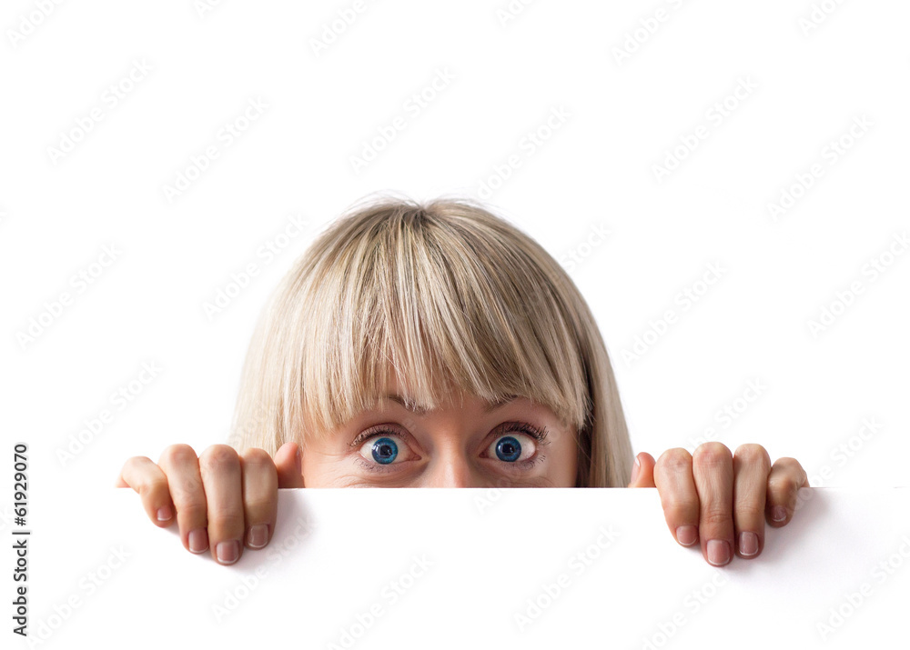 Surprised woman hiding behind blank whiteboard Surprised woman hiding behind blank whiteboard