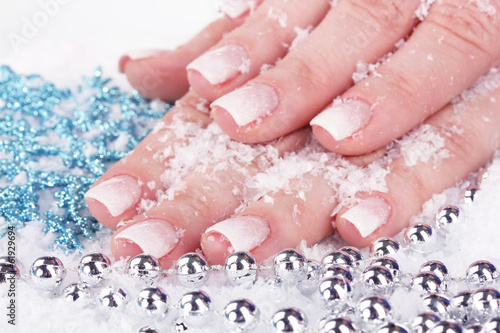 hands with snow, snowflakes and beads closeup