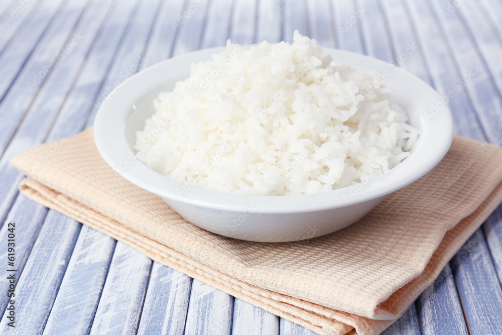 Cooked rice in bowl on wooden background