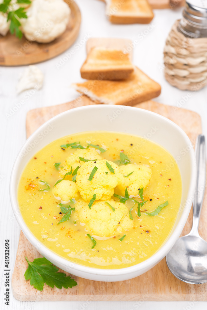 cauliflower soup with curry in a bowl, top view