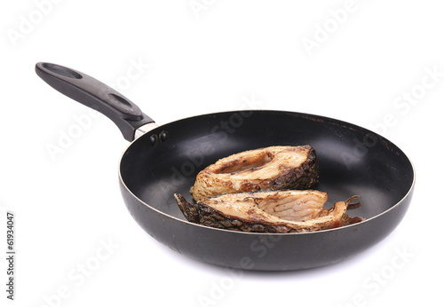 Grilled carp steaks on black pan.