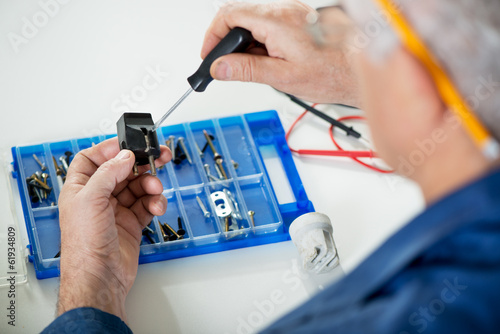 Electrician checking old power plug.