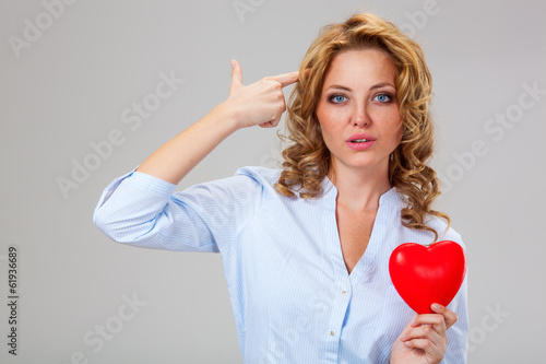 seriuosly woman holding red heart symbol photo