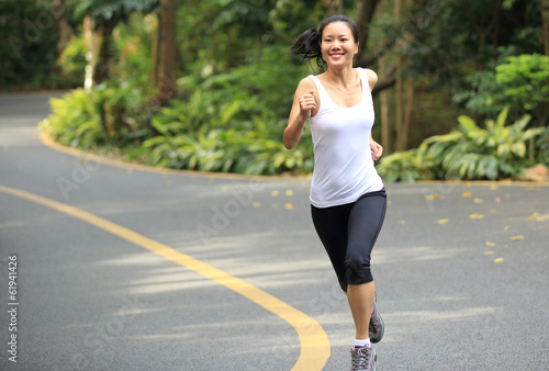 woman runner jogging at driveway in forest