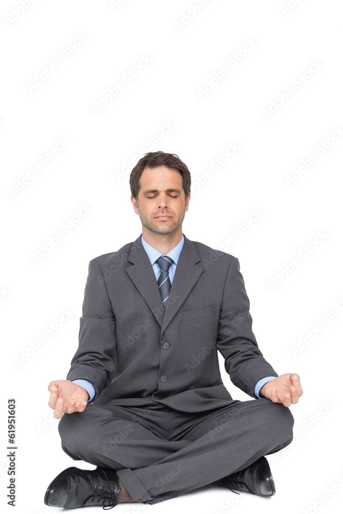 Peaceful businessman meditating in lotus pose Peaceful businessman meditating in lotus pose
