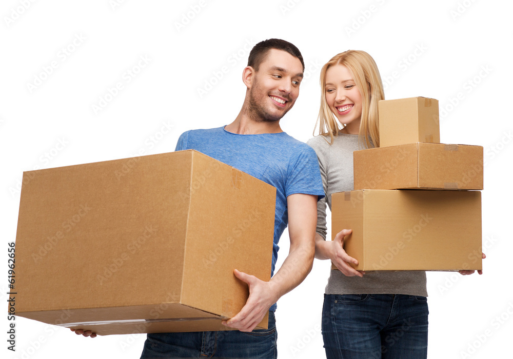 smiling couple holding cardboard boxes smiling couple holding cardboard boxes