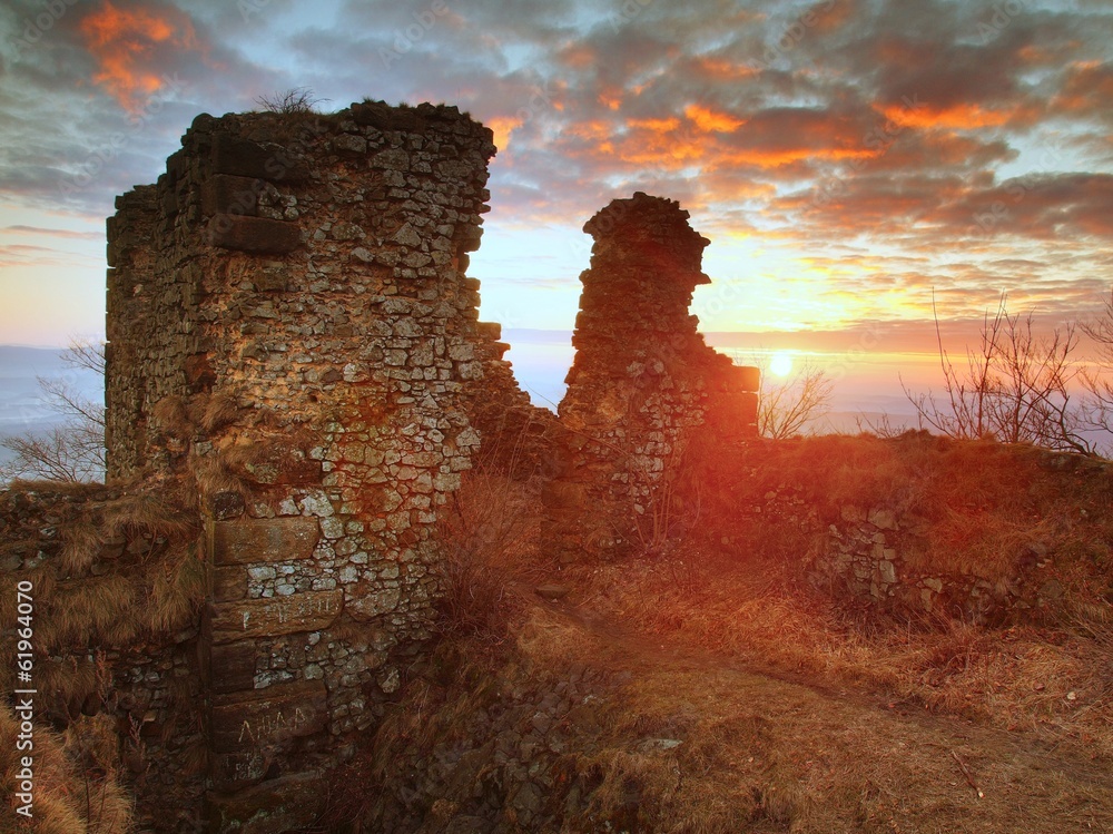 The stony ruin of medieval stronghold on the peak of rocky hill