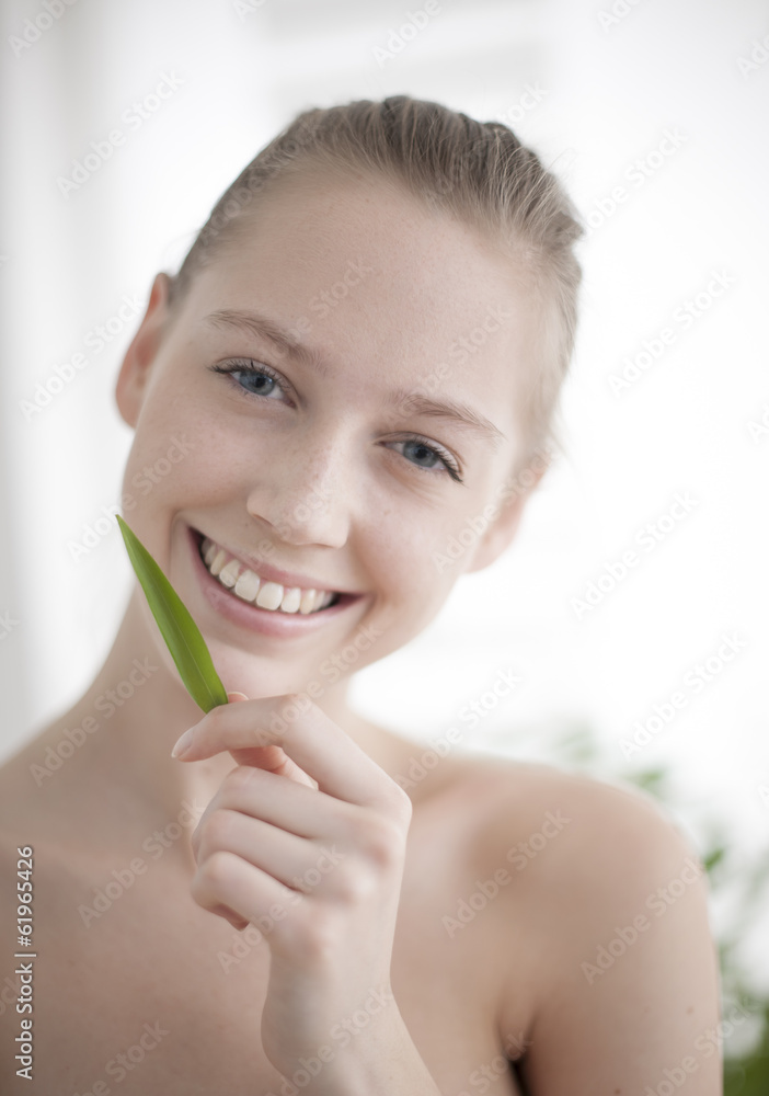 portrait of a beautiful young woman holding a bamboo leaf near h portrait of a beautiful young woman holding a bamboo leaf near h