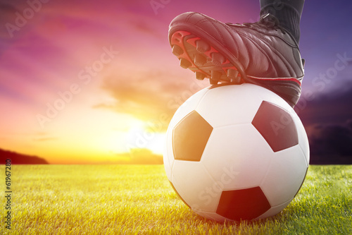 Obraz na plátne Football or soccer ball at the kickoff of a game with sunset